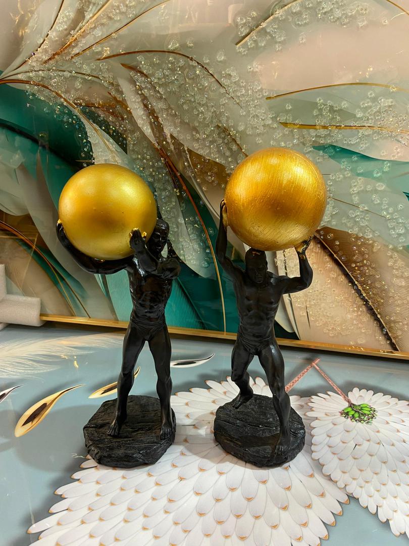 Bronze Atlas figurines holding gold orbs