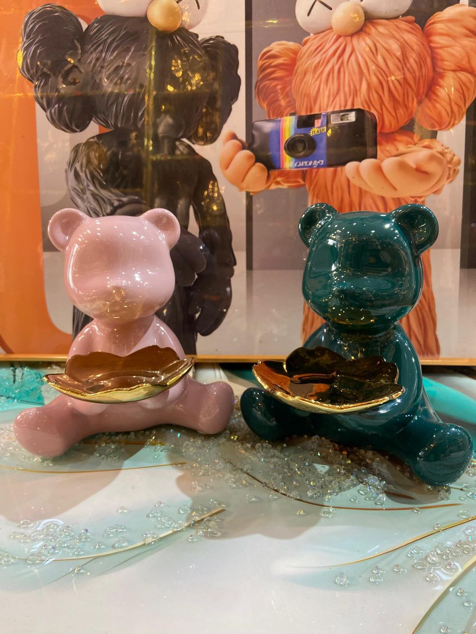 Pink and teal gummy bear figurines with gold dishes